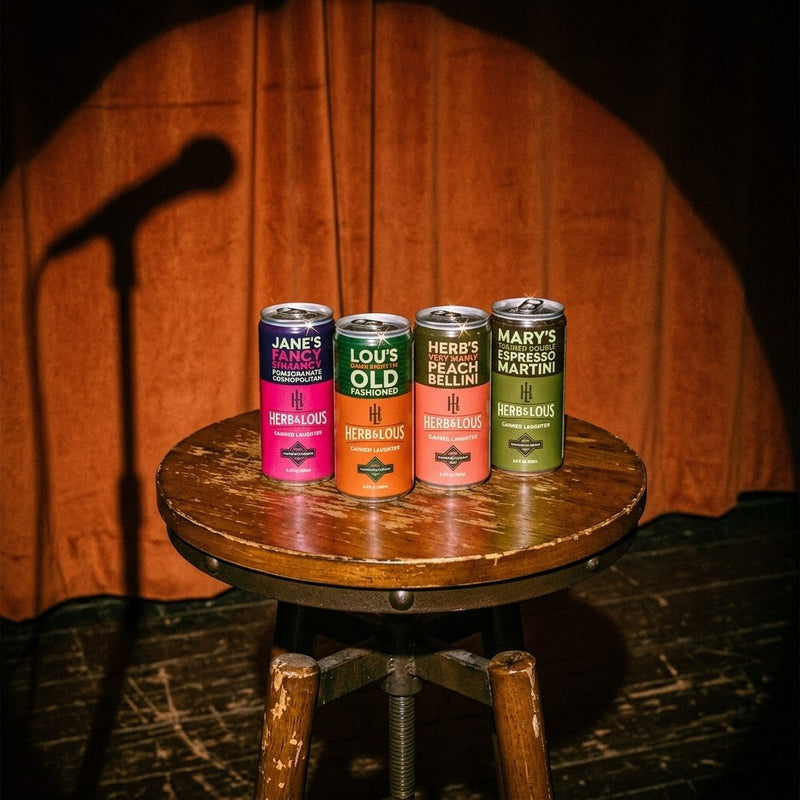Herb & Lou's four cans, Jane, Lou, Herb and Mary, on a stool on a comedy stage