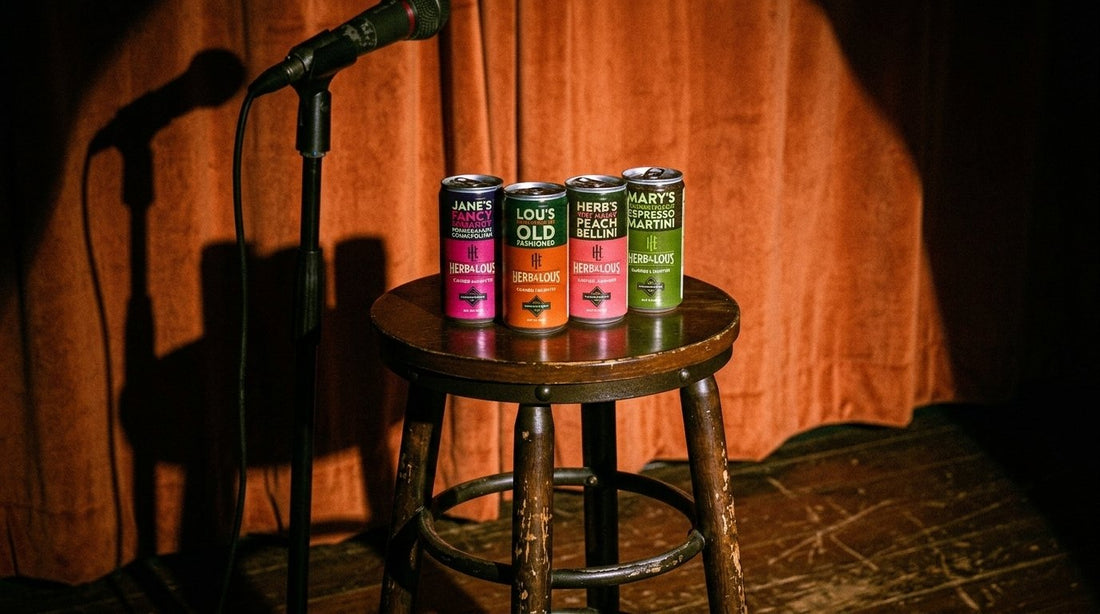 Herb & Lou's four cans on a stool next to a microphone on a comedy stage